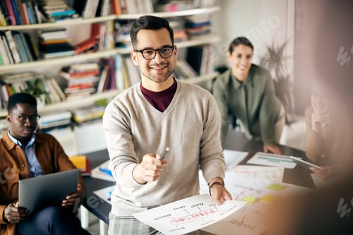 Preview: Creative marketing manager giving presentation to his coworkers during a meeting in the office.