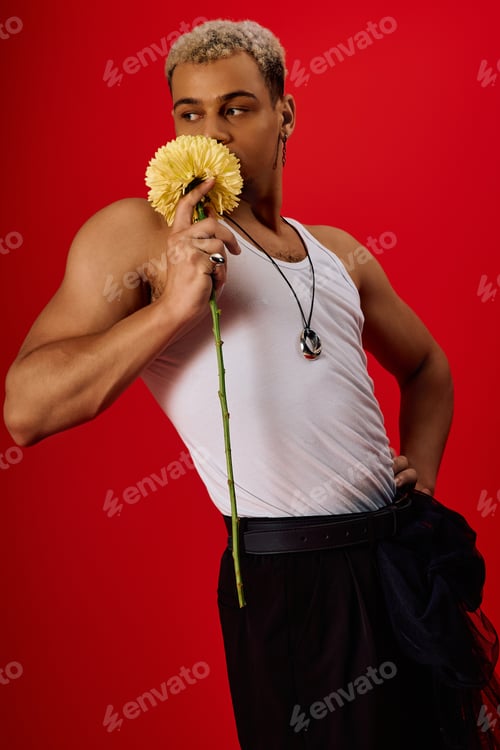 Preview: Young african american man showcases trendy style in vibrant red studio setting