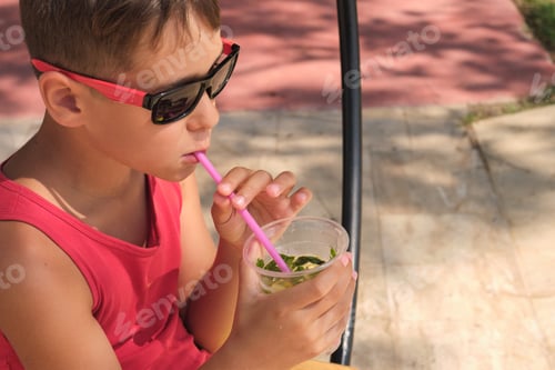 Preview: Child enjoying a beverage; warmth and refreshment. Taps into themes of sustainable, reusable