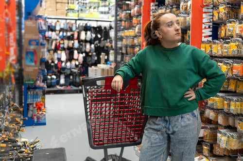 Preview: Young woman shopping for hardware in retail store