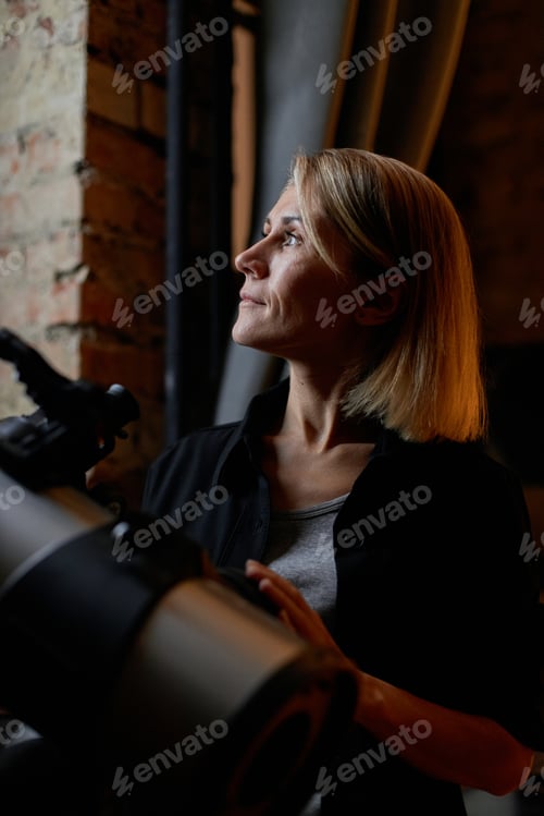 Preview: Mature woman learning astronomy looking at sky at night