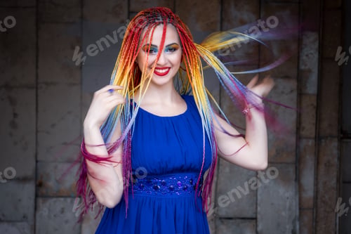 Preview: A funny girl with bright makeup and colored braids in a light blue dress is spinning and laughing