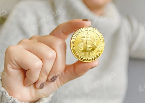 Preview: Closeup of a woman holding a single bitcoin
