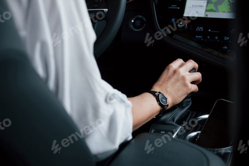 Preview: Switches gear. Close up view of woman's hands in the beautiful modern black colored car