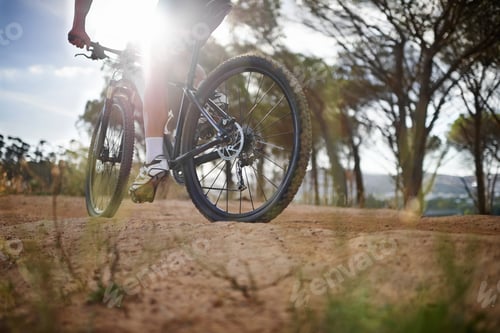 Preview: Pushing himself to new fitness heights. Cropped view of a man mountain biking in nature.