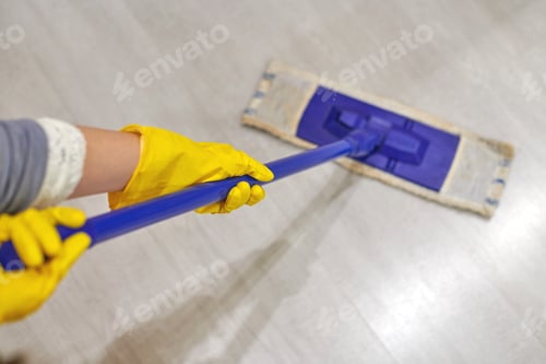 Preview: Girl in protective gloves cleaning floor using flat wet mop.