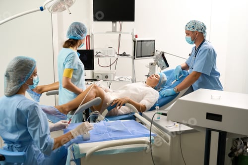 Preview: Hospital staff doing ultrasound examination to pregnant female patient