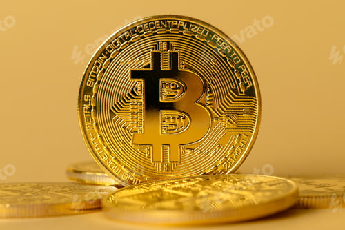 Preview: Closeup of gold bitcoin on yellow backgound
