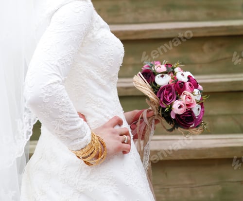 Preview: bride with gold bracelets and bouquet