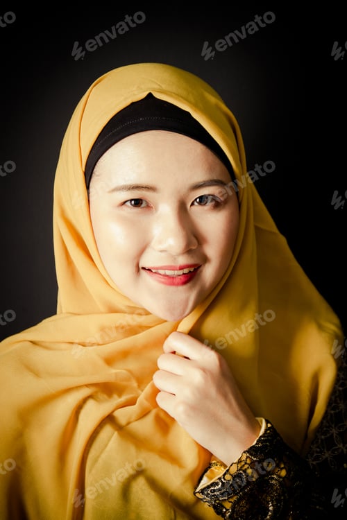Preview: Portrait of beautiful young muslim woman on a black background.