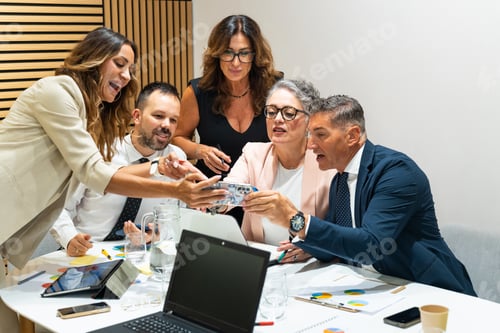 Preview: Business people working together using mobile phone in meeting room