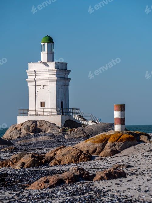 Preview: Shelley Point lighthouse on a rocky beach on a sunny day in South Africa