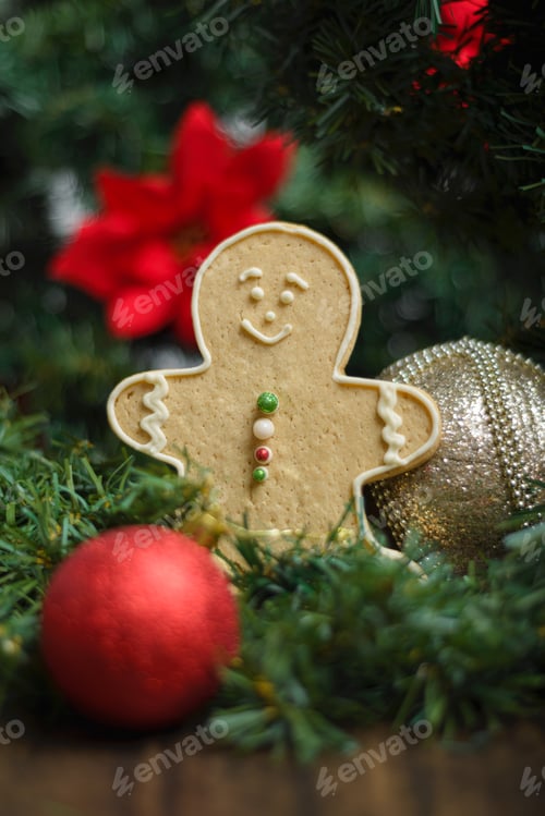 Preview: Gingerbread man cookie and ornaments on a Christmas tree. Christmas background, selective focus.
