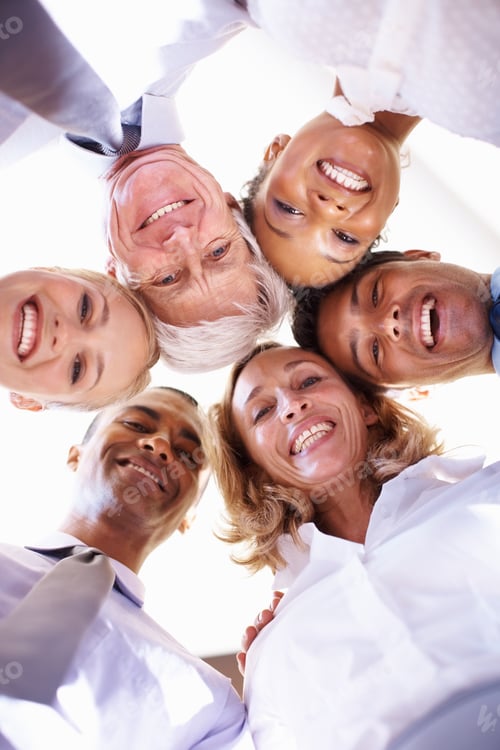 Preview: Working towards same goal. Low angle view of multi racial business team in huddle at office.