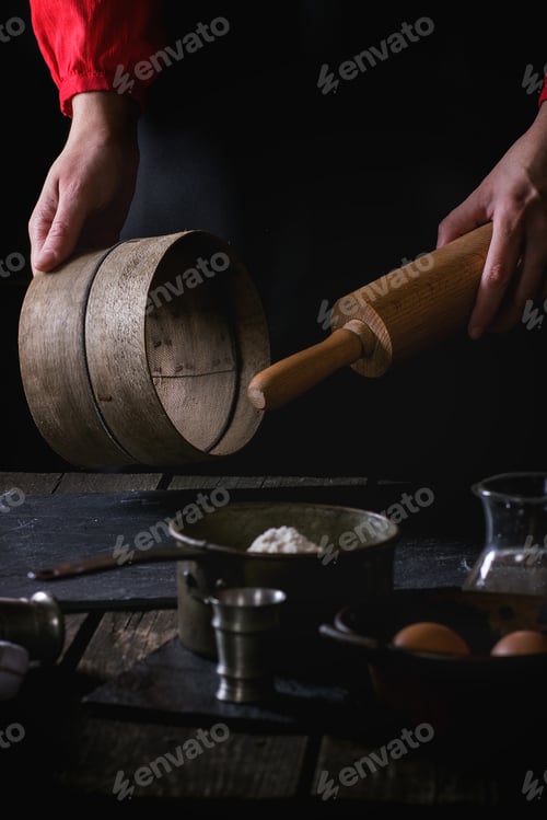 Preview: Female hands with wooden rolling-pin and sieve