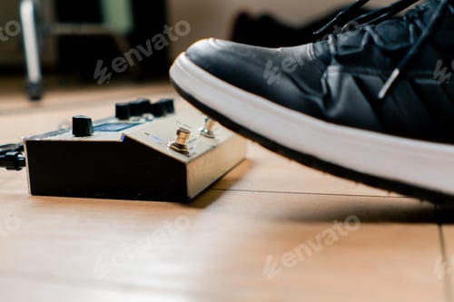 Preview: musician's male foot pressing bass drum pedal or bass electric guitar in recording studio close-up