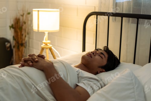 Preview: Asian attractive man lying down on bed in bedroom, dreaming at night.