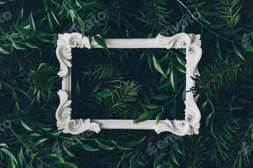Preview: Creative winter layout made of branches and leaves with white decorative frame. Flat lay.