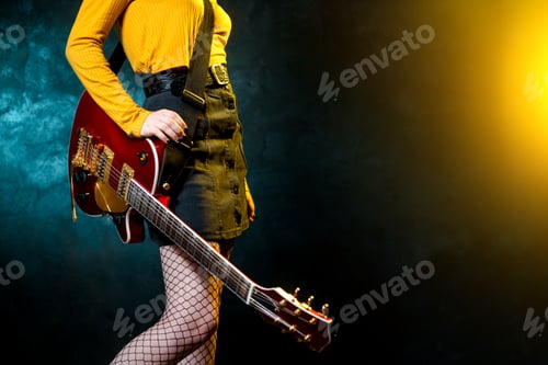 Preview: Close-up photo of young hipster woman legs and red guitar in neon lights.