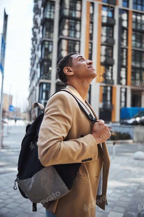 Preview: Close up of dreamy man looking at modern building