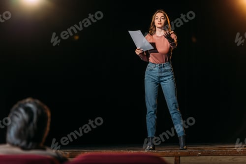 Preview: selective focus of stage director and actress performing role in theater