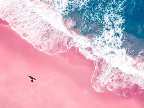 Preview: An aerial view of a surfer walking with a surfboard on a pink sandy beach in Australia