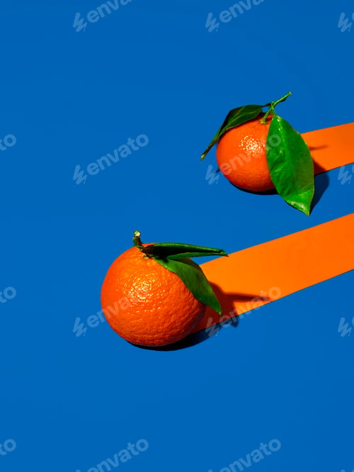 Vista previa: Two oranges on vivid blue background with trailing orange stripes