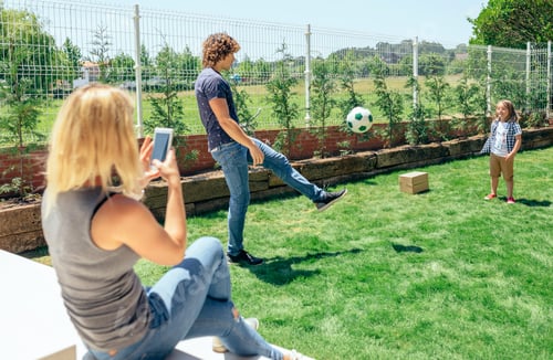 Visualização: Mãe tirando foto do marido e do filho brincando