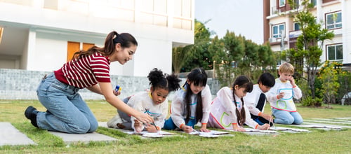 Preview: Group of student coloring on painting board outdoors in school garden.