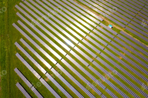 Preview: Aerial view of solar power plant on green field. Electric panels for producing clean ecologic energy
