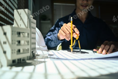 Preview: Architect man working on project of residential, using divider compass tool on blueprint