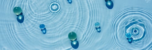 Preview: Abstract background, texture of blue water with round ripples with transparent balls, capsules