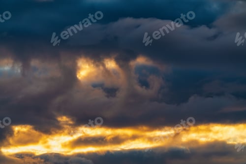 Preview: Impressive clouds in sky illuminated by rays of sun at sunset to change weather. Multicolored