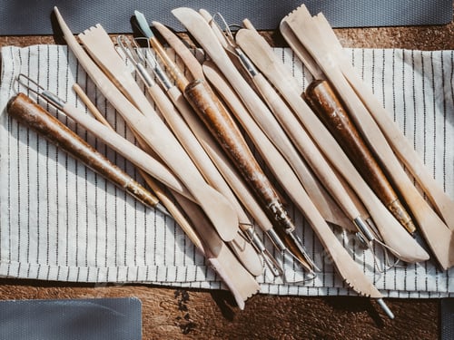 Preview: Set of clay modeling tools on white napkin background on wood table