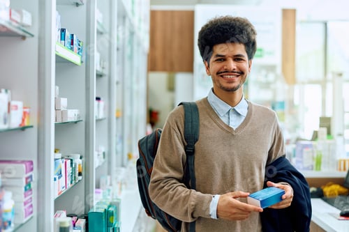 Preview: Happy Muslim man buying in a pharmacy and looking at camera.