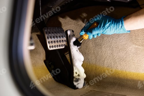 Preview: Car detailing procedure, closeup worker hand with brush cleaning pedals