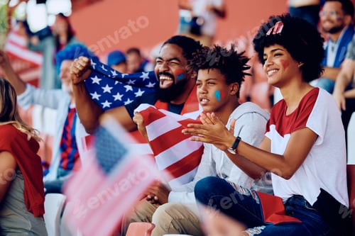 Preview: Happy black family cheering for USA during sports match at the stadium.
