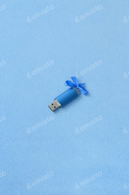 Preview: Brilliant blue usb flash memory card with a blue bow lies on a blanket of soft and furry
