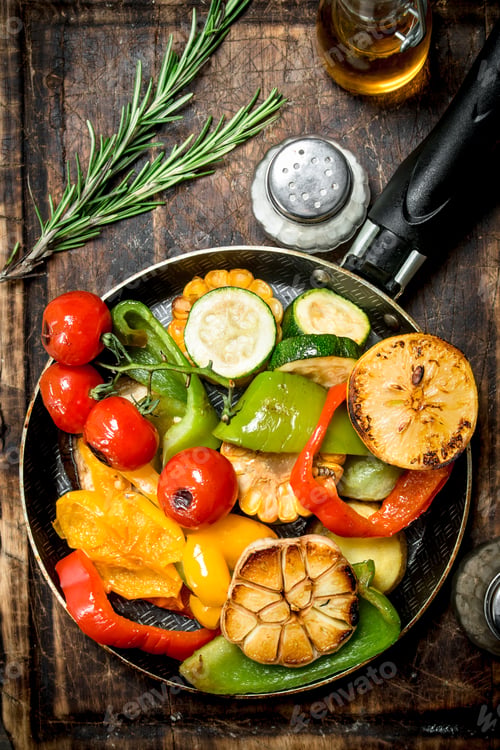 Preview: Assortment of grilled vegetables with a pan of herbs and spices on a cutting Board.