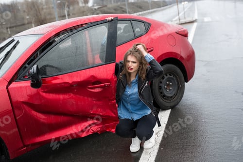 Preview: Woman sits near a broken car after an accident. call for help. car insurance