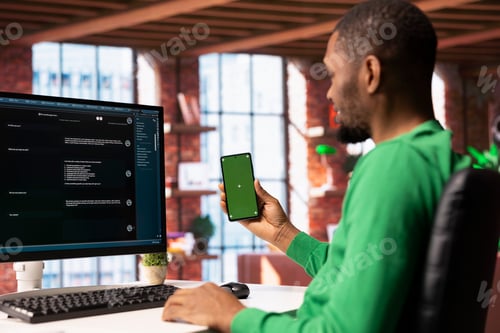 Preview: Man at home holding mockup smartphone asks questions to AI LLM chatbot