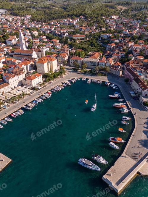 Preview: Aerial view of a picturesque coastal town with a marina and red-roofed buildings. Bol, Croatia.