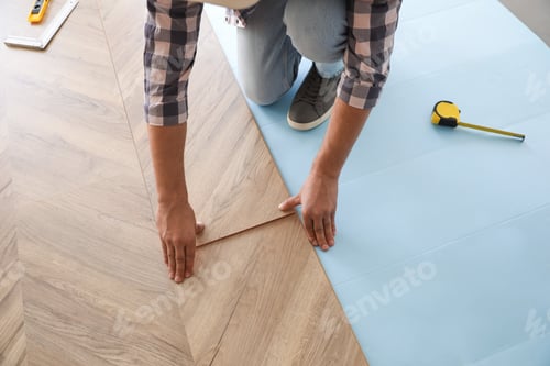 Aperçu: Travailleur installant un plancher en bois stratifié à l'intérieur, gros plan