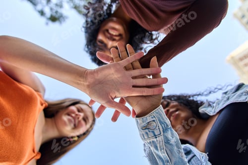 Preview: Group of diverse women joining hands in a circle outdoors