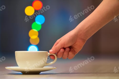 Preview: Hand holding white cup of coffee with colorful bokeh steam