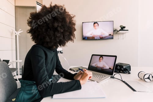 Preview: Person engaged in a video conference at a modern workspace.