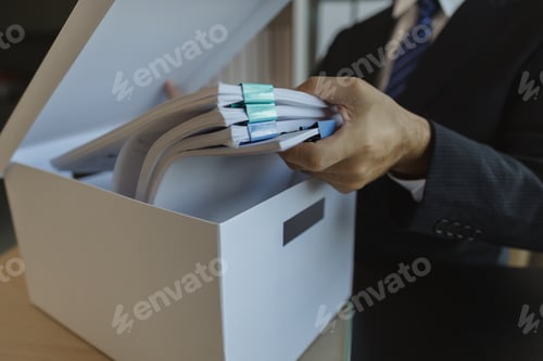 Preview: An office worker is putting important documents in boxes to prevent loss. A businessman is putting i