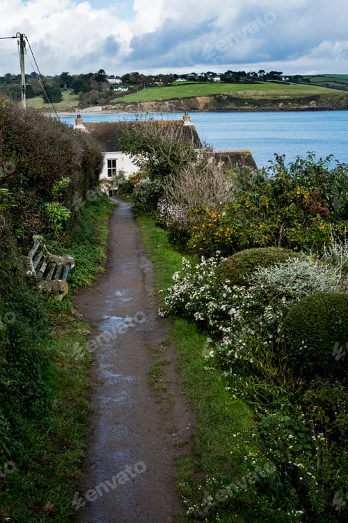 Preview: High angle view along a muddy path to a coastal cottage.