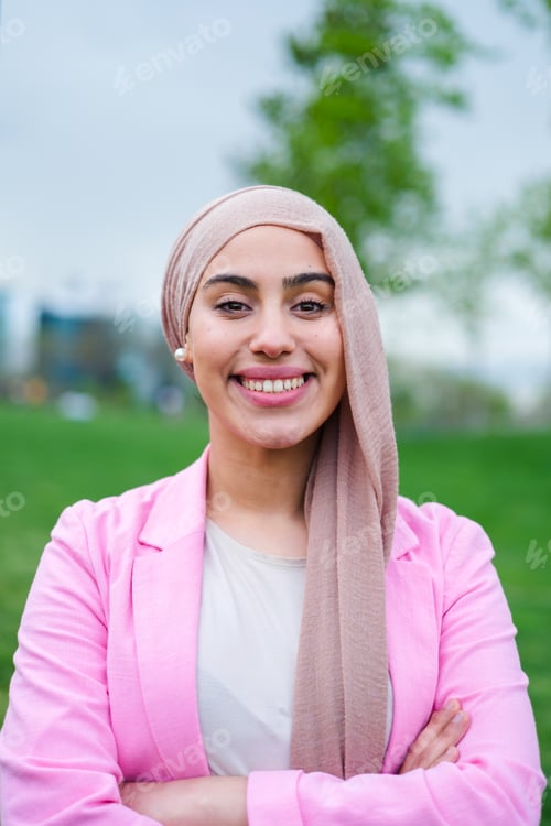 Preview: portrait of young woman wearing hijab and smiling. happy outdoors