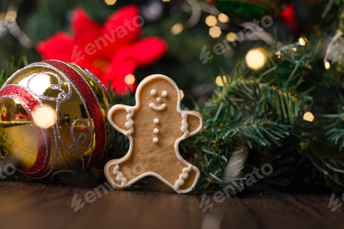 Preview: Gingerbread man cookie and Christmas ornaments on wooden table.